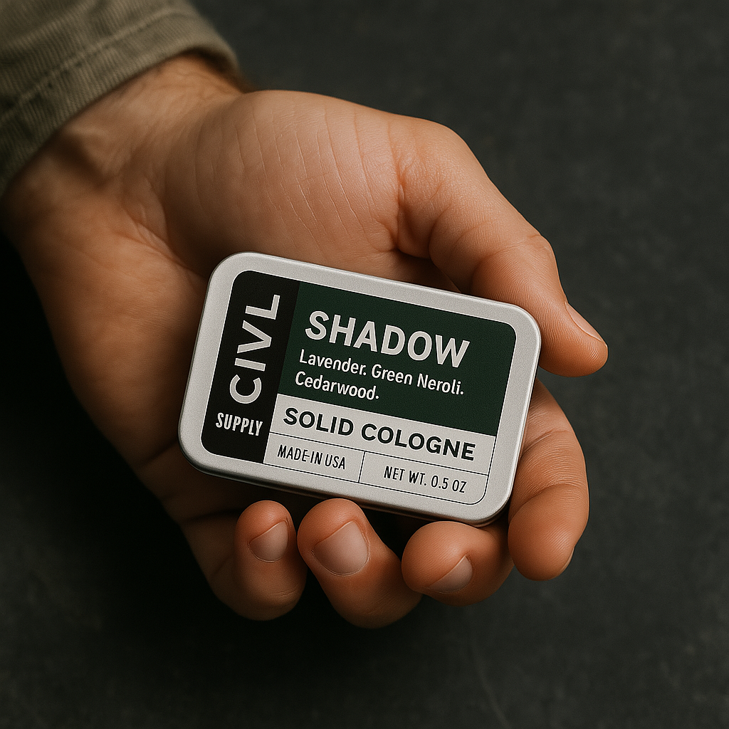 A small metal tin labeled 'SHADOW' containing solid cologne. The packaging is minimalistic with a green and black label, and the product is identified as 'CIVL Supply', 'Made in USA', with a net weight of 0.5 OZ