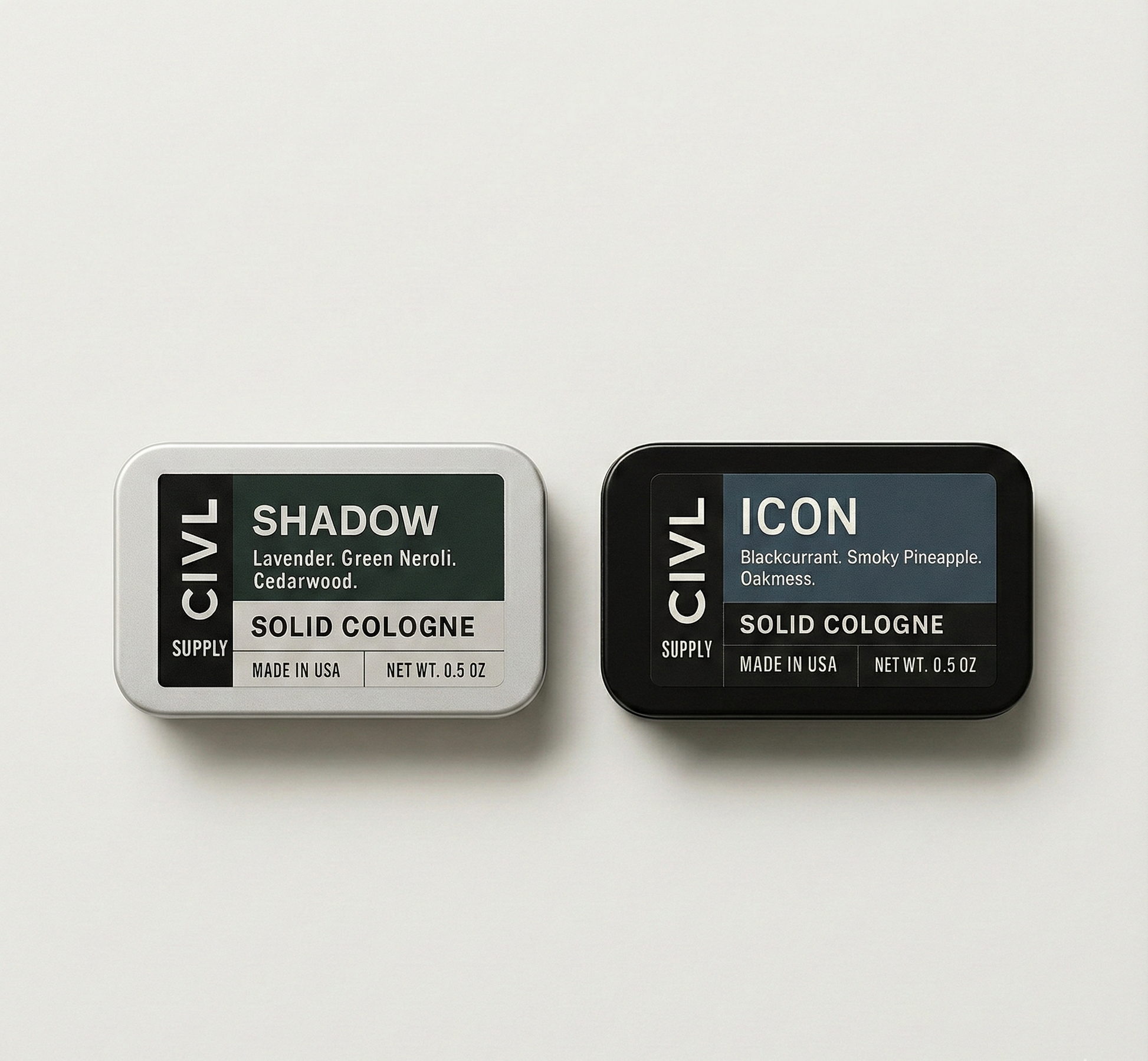 Two tins of Civil Supply solid cologne on a light gray background